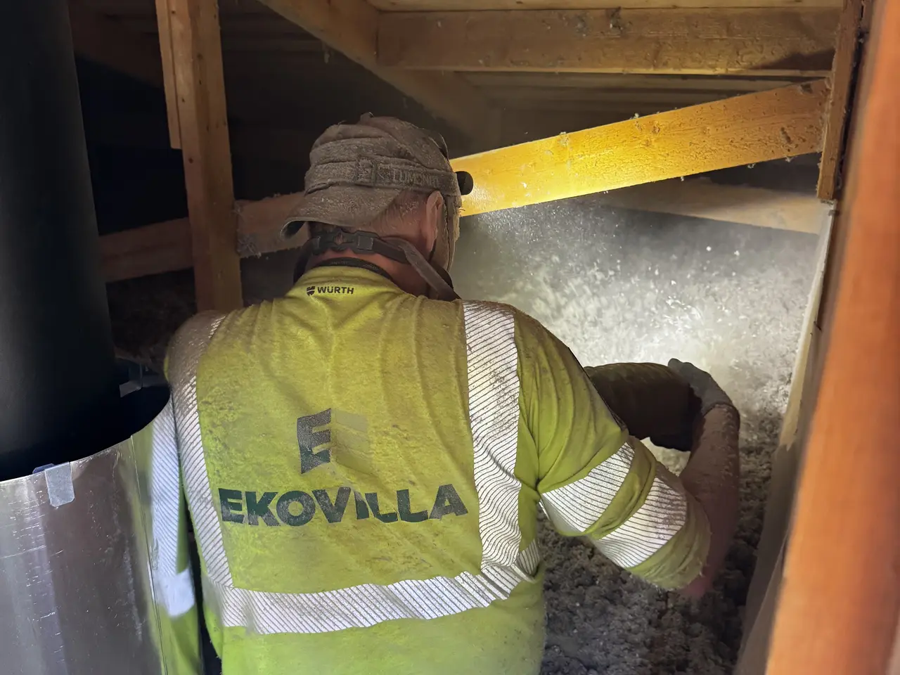 Ekovillas installatör vid vindsluckan med slangen redo